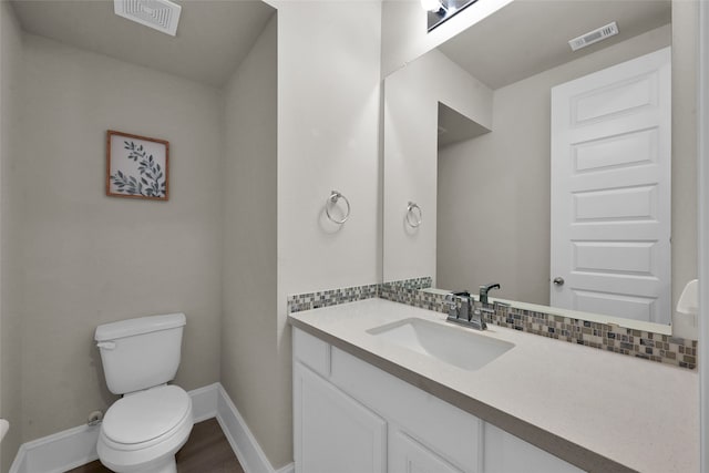 bathroom with hardwood / wood-style floors, backsplash, toilet, and vanity