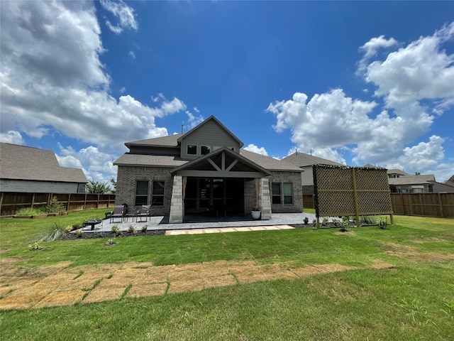 rear view of property featuring a lawn and a patio area