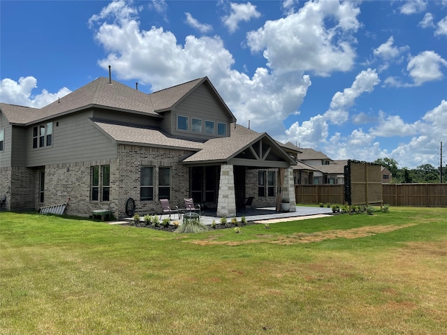 rear view of house featuring a patio and a lawn