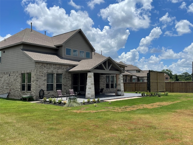 rear view of property with a patio and a lawn