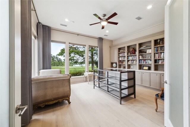 office space with ceiling fan, light hardwood / wood-style floors, built in features, and ornamental molding