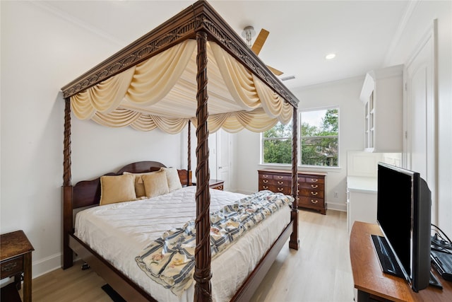 bedroom with light hardwood / wood-style floors and crown molding