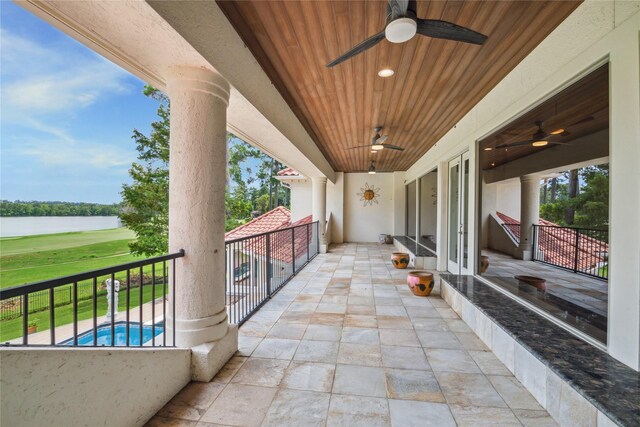 view of patio / terrace with a balcony, a water view, and ceiling fan