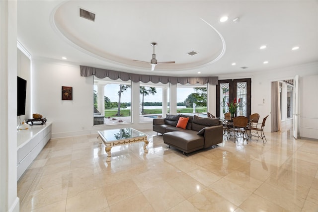 living room featuring french doors, crown molding, light tile patterned floors, ceiling fan, and a raised ceiling