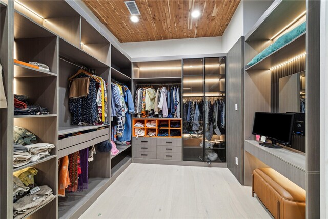 walk in closet with light hardwood / wood-style flooring