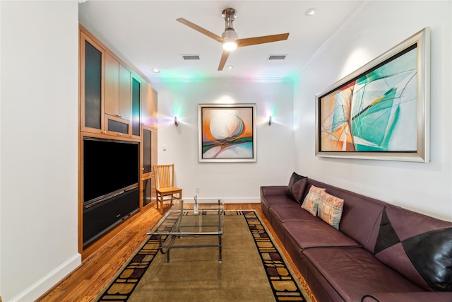 living room with ceiling fan, dark wood-type flooring, and ornamental molding