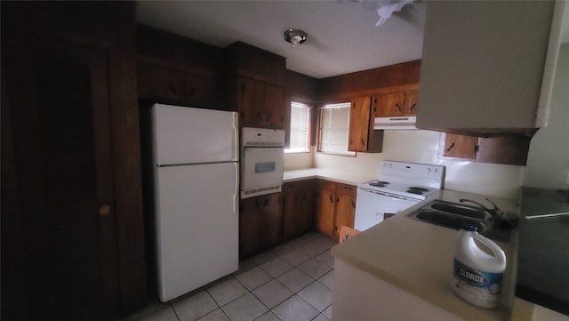 kitchen with sink, white appliances, and light tile patterned floors