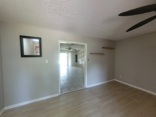 spare room featuring ceiling fan, a textured ceiling, and wood-type flooring