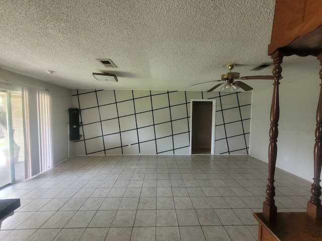 tiled spare room featuring ceiling fan, a textured ceiling, and electric panel