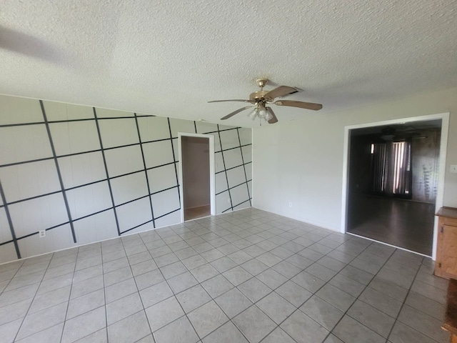 unfurnished bedroom with ceiling fan, a textured ceiling, and tile patterned floors