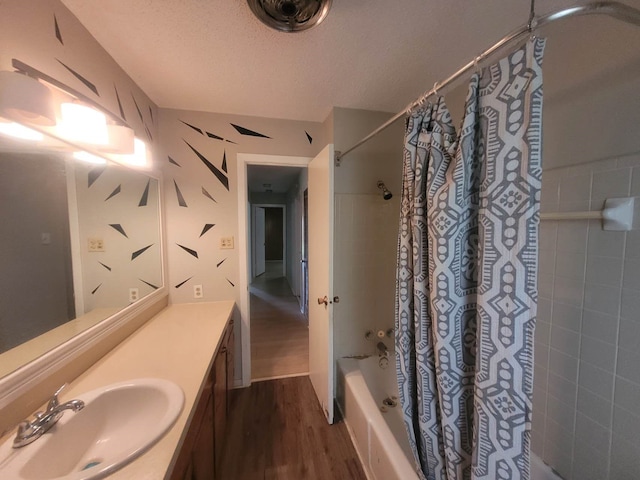 bathroom featuring hardwood / wood-style flooring, a textured ceiling, vanity, and shower / tub combo with curtain