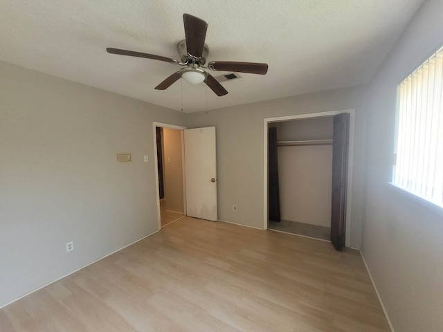 unfurnished bedroom with ceiling fan, a closet, and light hardwood / wood-style floors