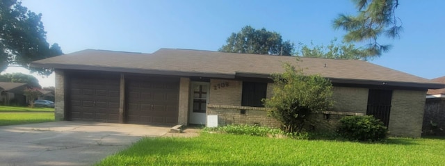 single story home featuring a garage and a front lawn