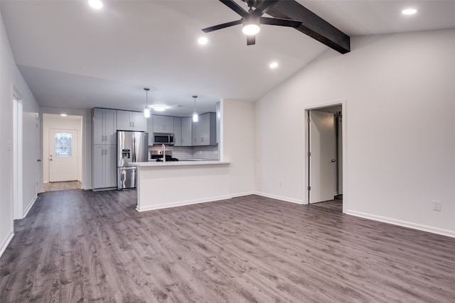 unfurnished living room featuring ceiling fan, sink, lofted ceiling with beams, and dark hardwood / wood-style floors