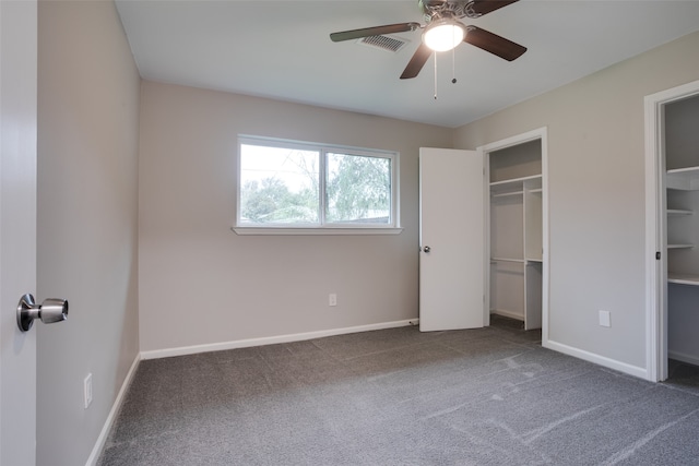 unfurnished bedroom with dark colored carpet, ceiling fan, and a closet