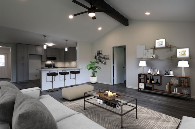 living room with vaulted ceiling with beams, dark hardwood / wood-style flooring, ceiling fan, and sink