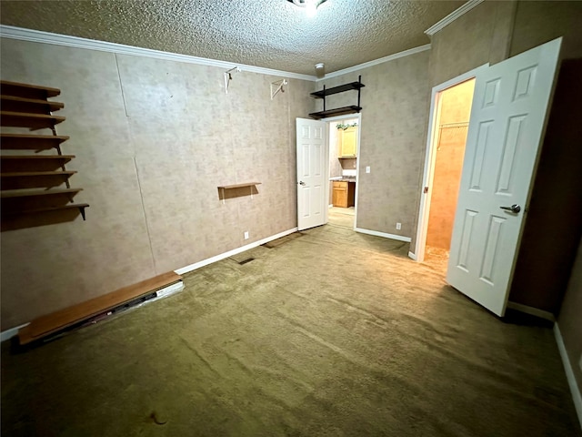 unfurnished bedroom with a textured ceiling, a barn door, carpet floors, and crown molding