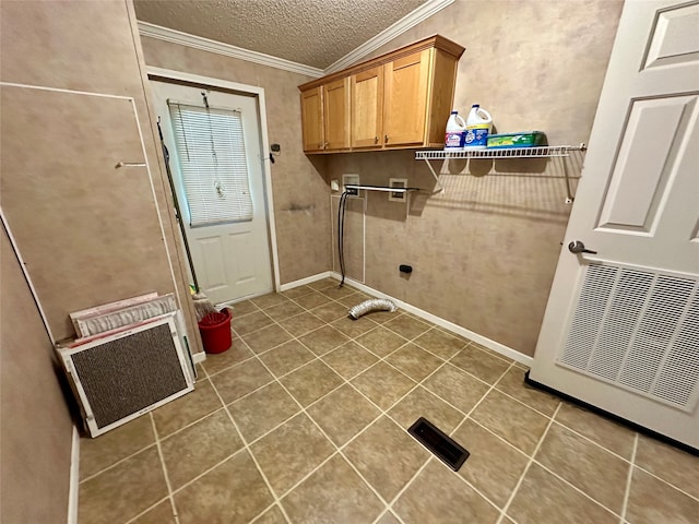 laundry room featuring cabinets, a textured ceiling, ornamental molding, and tile patterned floors