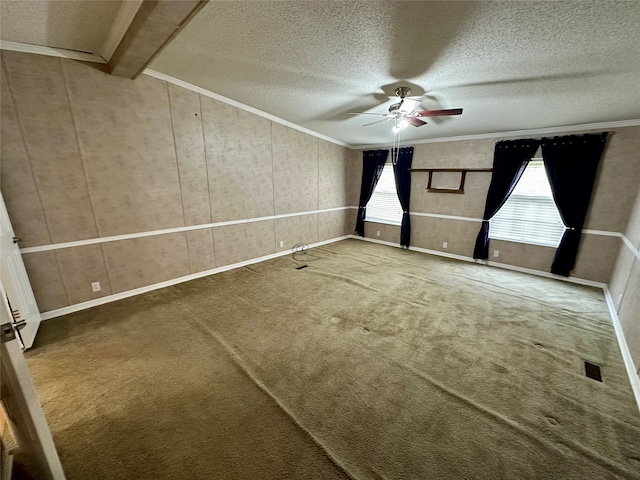 carpeted spare room with lofted ceiling with beams, a wealth of natural light, ceiling fan, and a textured ceiling