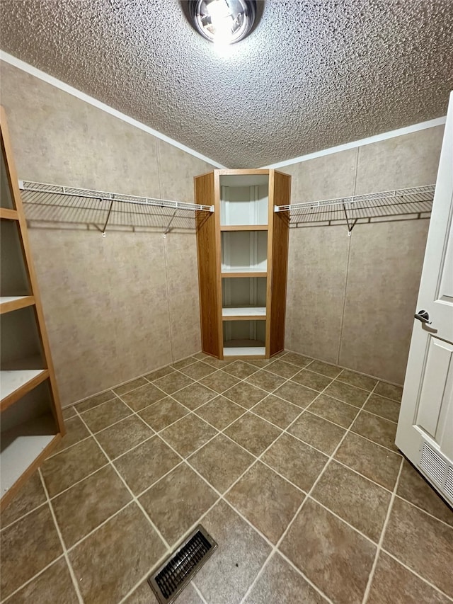 walk in closet with dark tile patterned flooring