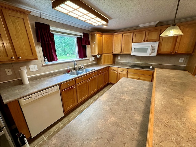 kitchen featuring a textured ceiling, hanging light fixtures, sink, and white appliances