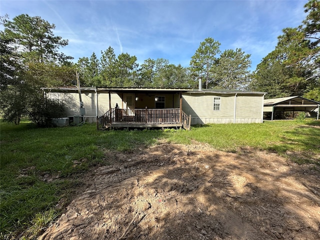 back of property with a deck and a yard