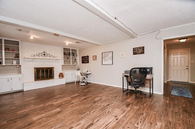 living room with hardwood / wood-style floors, a fireplace, a textured ceiling, and brick wall