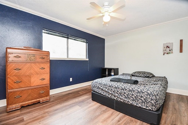 bedroom featuring ceiling fan, ornamental molding, and wood-type flooring