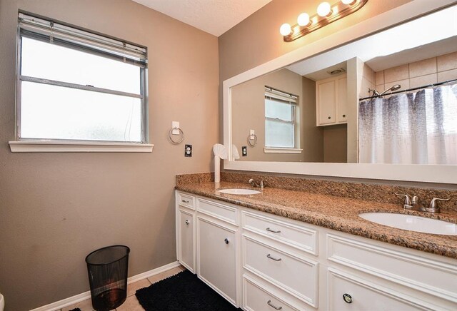 bathroom with double vanity and tile patterned flooring