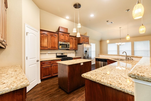 kitchen with sink, appliances with stainless steel finishes, and decorative light fixtures