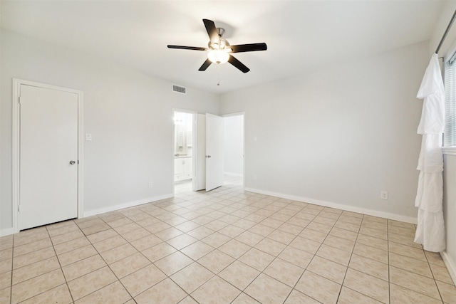 tiled spare room featuring ceiling fan