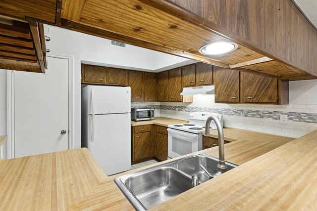 kitchen with decorative backsplash and white appliances