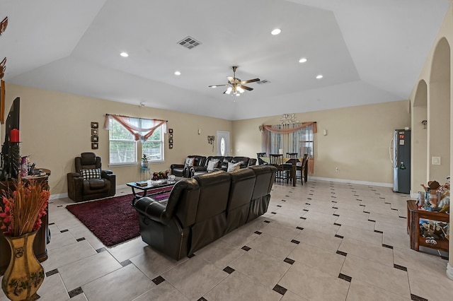 living room featuring ceiling fan, a raised ceiling, and light tile patterned floors