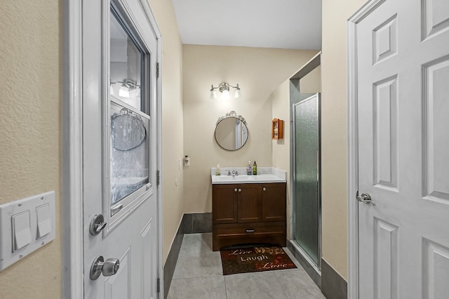 bathroom featuring a shower with shower door, vanity, and tile patterned floors