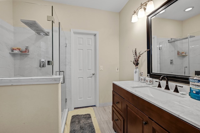 bathroom with a shower with shower door and vanity