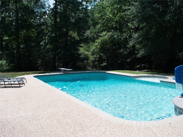 view of swimming pool featuring a diving board