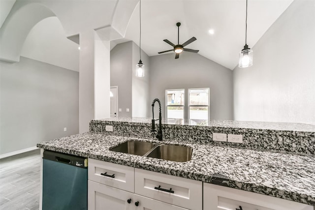 kitchen with white cabinetry, sink, dark stone countertops, stainless steel dishwasher, and light hardwood / wood-style flooring