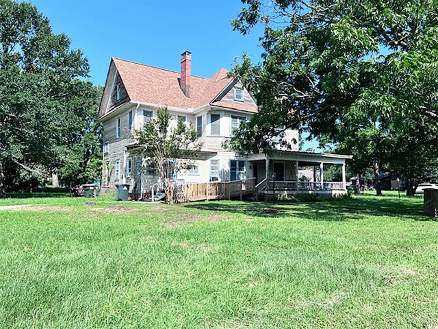 rear view of property with a lawn