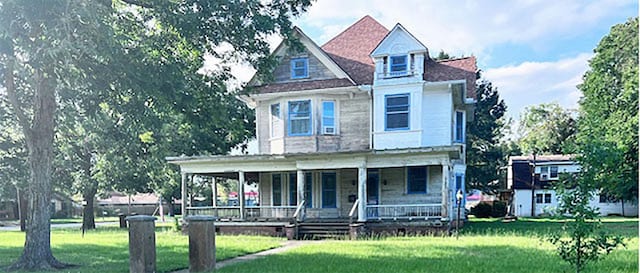 view of front facade featuring covered porch and a front yard