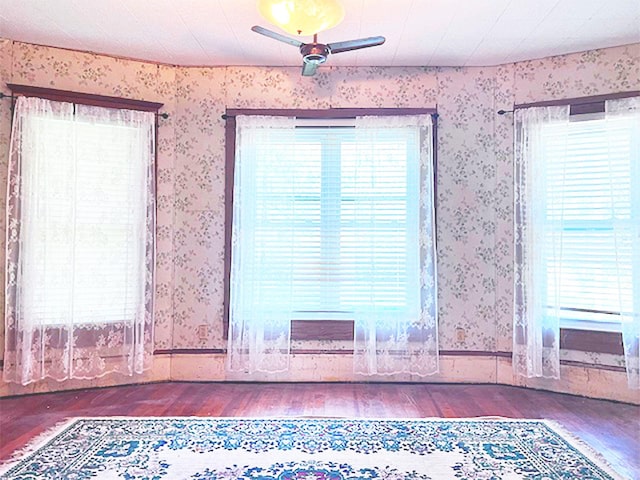 unfurnished room with dark wood-type flooring and ceiling fan