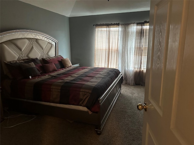 bedroom featuring lofted ceiling and carpet