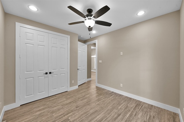 unfurnished bedroom with ceiling fan, light hardwood / wood-style flooring, and a closet