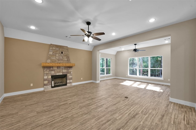 unfurnished living room with light hardwood / wood-style floors, lofted ceiling, and a fireplace