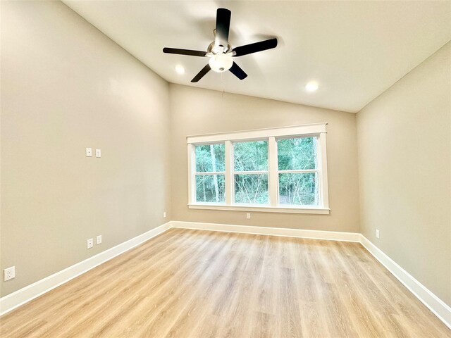 spare room featuring light wood-type flooring, vaulted ceiling, and ceiling fan