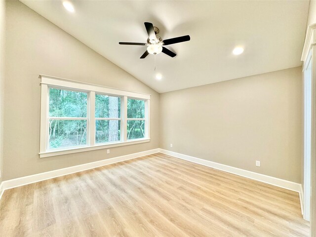 spare room featuring ceiling fan, light wood-type flooring, and vaulted ceiling