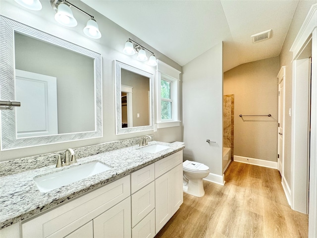 full bathroom with toilet, vanity, bathing tub / shower combination, lofted ceiling, and hardwood / wood-style flooring