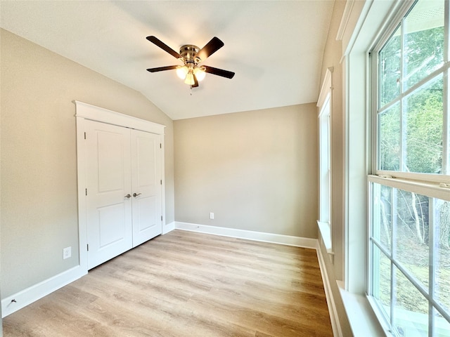 unfurnished bedroom featuring lofted ceiling, ceiling fan, and light hardwood / wood-style flooring