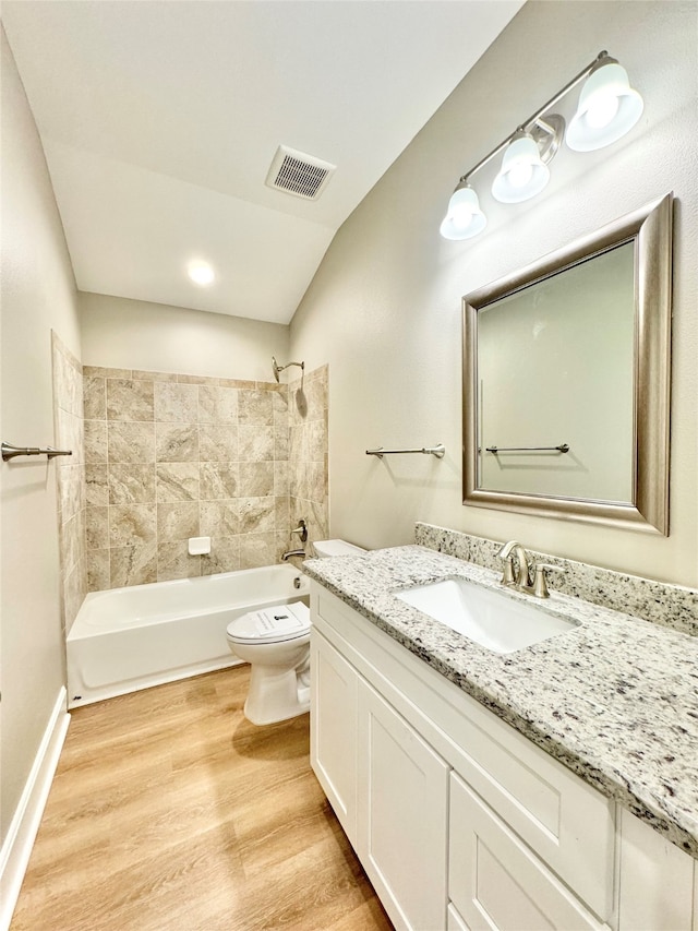 full bathroom featuring vanity, toilet, tiled shower / bath combo, and hardwood / wood-style flooring