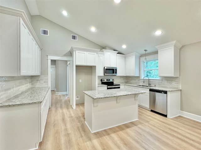 kitchen featuring sink, light stone countertops, appliances with stainless steel finishes, and white cabinetry