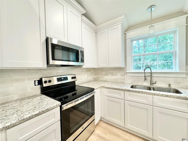 kitchen featuring light hardwood / wood-style floors, stainless steel appliances, sink, light stone counters, and white cabinets